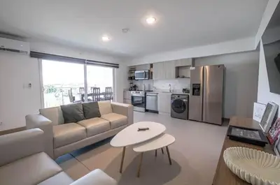 a living room with a couch and a table at Modern 3BR Condo at Viva Jaco w Pool & Gym in Jacó