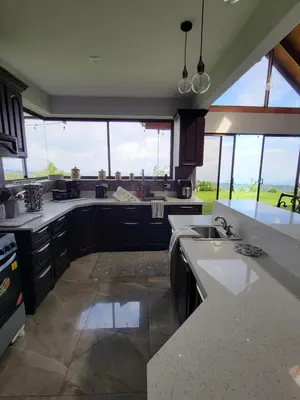a kitchen with black cabinets and a large window at A place to create dreams in Naranjo