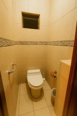 a small bathroom with a toilet and a window at Hotel Mirador Mayday Mountain View in Alajuela City