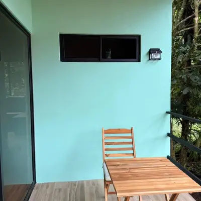 a wooden chair sitting next to a blue wall at Pozas y Cascadas La Presa Habitación 4 in Río Cuarto