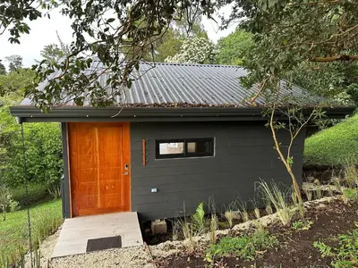 a small black house with a door and a window at BiBO Casa Savia in Monteverde Costa Rica