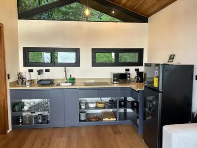 a kitchen with a counter and a refrigerator at BiBO Casa Savia in Monteverde Costa Rica