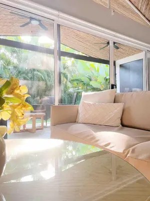 a couch in a room with a large window at Beach House & Resort Amenities at Ciudad del Mar Jaco in Jacó