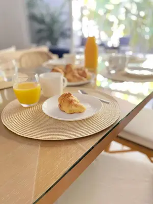 a table with a plate of food and orange juice at Beach House & Resort Amenities at Ciudad del Mar Jaco in Jacó