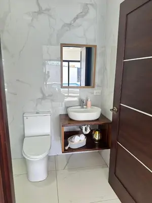 a bathroom with a sink and a toilet and a mirror at Luxury Home Tamarindo 3BR- 4BA and Private Pool in Tamarindo