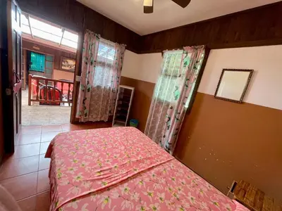 a bedroom with a bed with pink sheets and a window at Casona de Pani habitacion#2 in Liberia