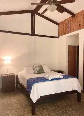 a bedroom with a bed with a ceiling fan at Rio Lindo Hotel in Dominical