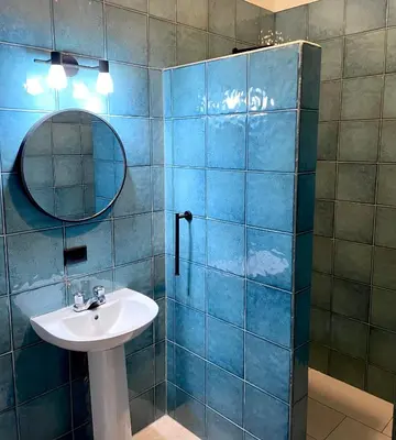 a blue tiled bathroom with a sink and a mirror at Rio Lindo Hotel in Dominical