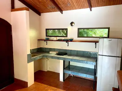 a kitchen with a counter and a refrigerator at Rio Lindo Hotel in Dominical
