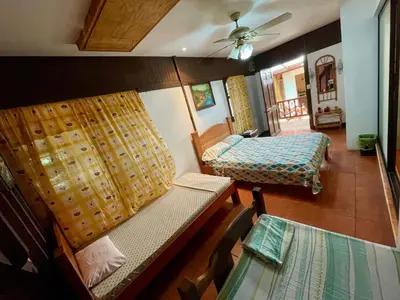 a living room with two beds and a table at Casona de Pani habitacion#3 in Liberia