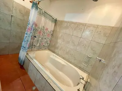 a bath tub in a bathroom with a shower curtain at Casona de Pani habitacion#3 in Liberia
