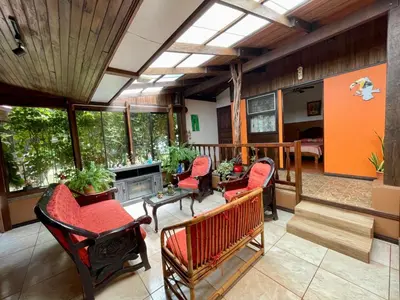 a living room with red chairs and a balcony at Casona de Pani habitacion#3 in Liberia