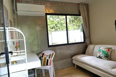 a small room with a couch and a window at Pura Vida Jungle Container - Near Avellanas Beach in Tapantí