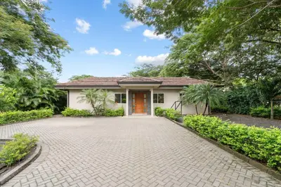 a house with a driveway in front of it at Beautiful Home in a Gated Neighborhood Walking Distance to the Beach with Garden Views and a Pool in Brasilito