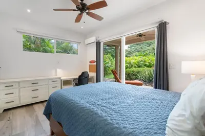 a bedroom with a blue bed and a window at Beautiful Home in a Gated Neighborhood Walking Distance to the Beach with Garden Views and a Pool in Brasilito
