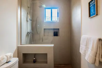 a bathroom with a shower and a toilet and a window at Triskele Retreat - Casa Earth in Esterillos