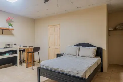 a bedroom with a bed and a table and a desk at Marsol 2 in Uvita