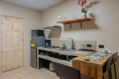a kitchen with a sink and a refrigerator and a table at Marsol 2 in Uvita