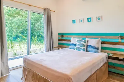 a bedroom with a large bed with a large window at Triskele Retreat - Casa Ocean in Esterillos