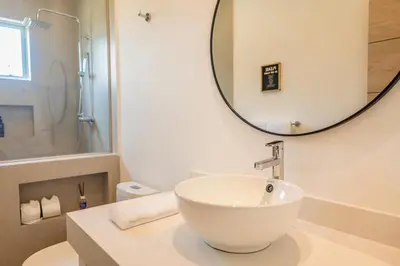 a bathroom with a white sink and a mirror at Triskele Retreat - Casa Ocean in Esterillos