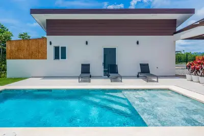 a swimming pool in front of a house at Triskele Retreat - Casa Ocean in Esterillos