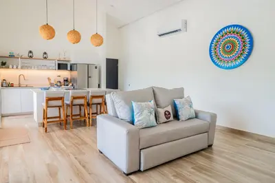a living room with a couch and a kitchen at Triskele Retreat - Casa Ocean in Esterillos