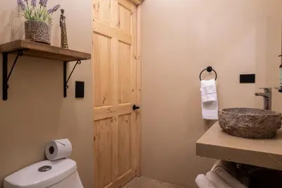 a bathroom with a white toilet and a sink at Marsol 1 in Uvita