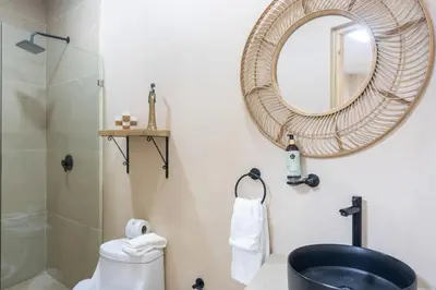 a bathroom with a shower and a sink and a mirror at Marsol 3 in Uvita