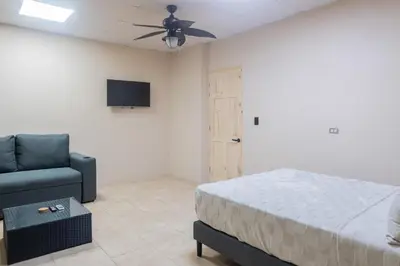 a bedroom with a bed and a couch and a television at Marsol 3 in Uvita