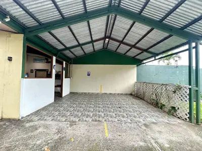 an empty building with a green ceiling and a parking lot at Room B – Perfect Rest in Heredia in Flor