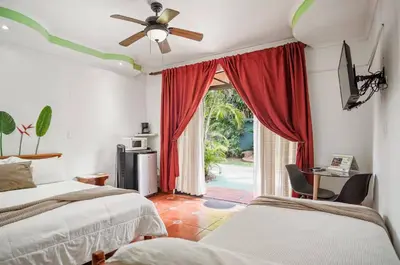 a bedroom with two beds and a door to a patio at Room C – Perfect Rest in Heredia in Flor