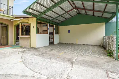 an empty parking lot in front of a building at Room C – Perfect Rest in Heredia in Flor