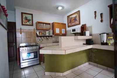 a kitchen with a stove and a counter top at Room E in Heredia – Excellent location in Flor