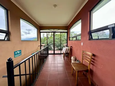 a hallway with windows and a staircase in a house at Room E in Heredia – Excellent location in Flor
