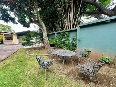 a table and chairs in a yard with a tree at Apartment F -G Heredia – Good Location in Flor