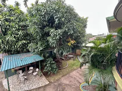 a garden with a building with a bench and trees at Relaxing H-I Heredia Apartment in Flor