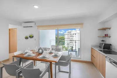 a kitchen and dining room with a table and chairs at Contemporary Viva Jaco Residences Suite with Pool in Jacó