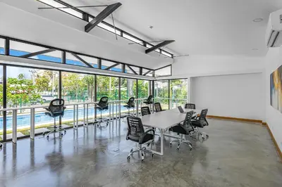 a conference room with a table and chairs and windows at Contemporary Viva Jaco Residences Suite with Pool in Jacó