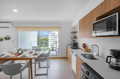 a kitchen with a table and chairs and a counter top at Contemporary Viva Jaco Residences Suite with Pool in Jacó
