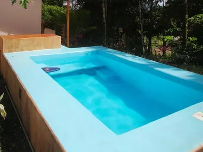a swimming pool in a backyard with blue water at Nature Observatory Studio with Private Pool in Chachagua