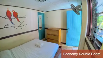 a small room with a bed and a dresser at Blue Iguana in Sámara