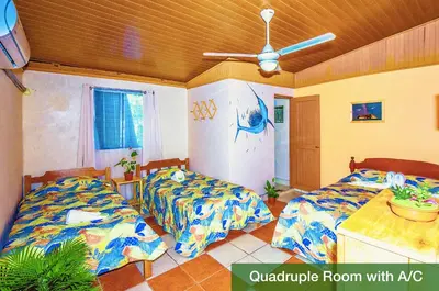 a bedroom with two beds and a ceiling fan at Blue Iguana in Sámara