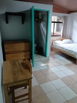 a room with a bedroom with a bed and a table at Blue Iguana in Sámara