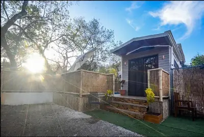 a small house with a stone fence and a fence at Casita VNV in Nosara