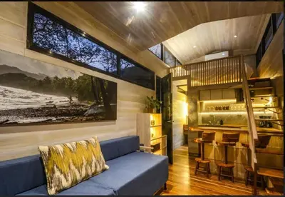 a living room with a blue couch and a kitchen at Casita VNV in Nosara