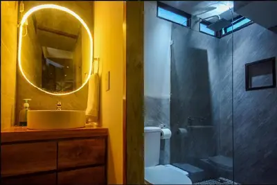 a bathroom with a sink and a shower with a mirror at Casita VNV in Nosara