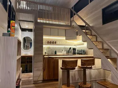 a kitchen with stairs leading up to a loft at Casita VNV in Nosara