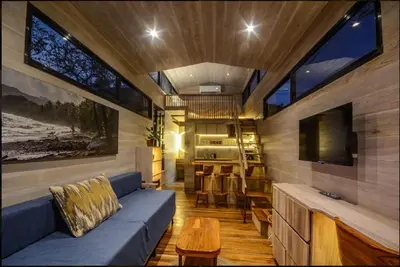 a living room with a blue couch and a tv at Casita VNV in Nosara