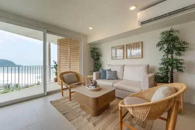 a living room with a couch and a table at Serene and Modern Beachfront Condo with Ocean Views in Jacó