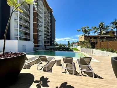 a group of chairs sitting next to a swimming pool at Serene and Modern Beachfront Condo with Ocean Views in Jacó